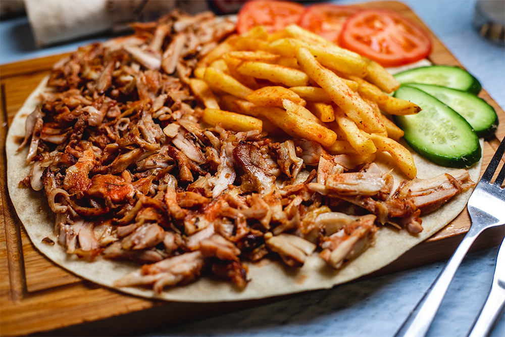 side view doner pita with french fries fresh cucumber tomato